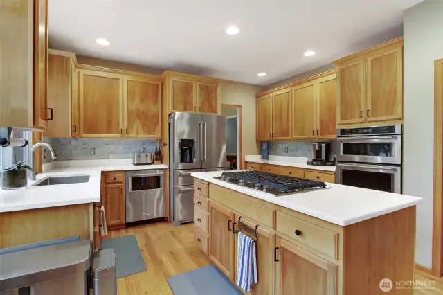 Kitchen with quartz countertops, spanish ceramic tile backsplash, 5 burner gas top and SS appliances.