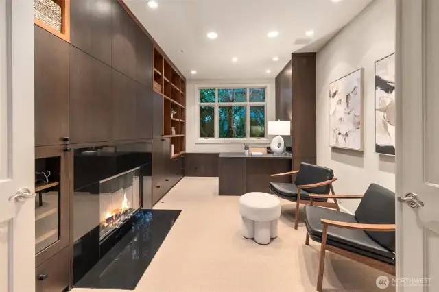 An inviting den showcases custom cabinetry, a sleek built-in desk, gas fireplace, and glamorous finishes—blending comfort with sophisticated functionality.