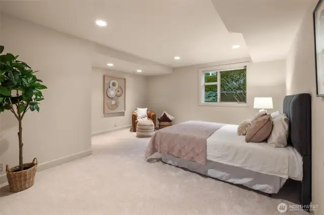 A generously sized lower-level bedroom offers comfort, privacy, and versatility for guests or extended living.