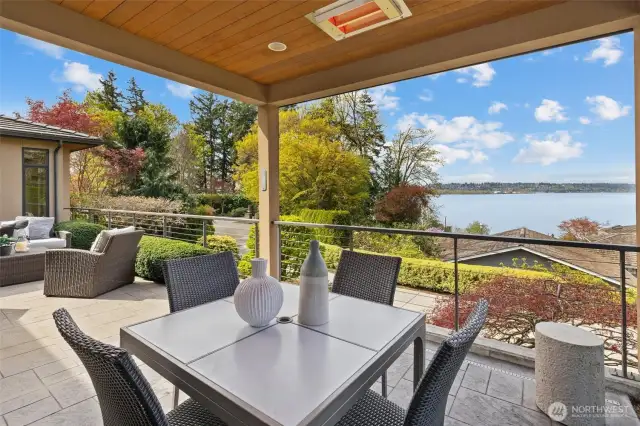 Al fresco dining beneath infrared heaters, complemented by Somfy automated shades, offers year-round comfort and effortless outdoor living.
