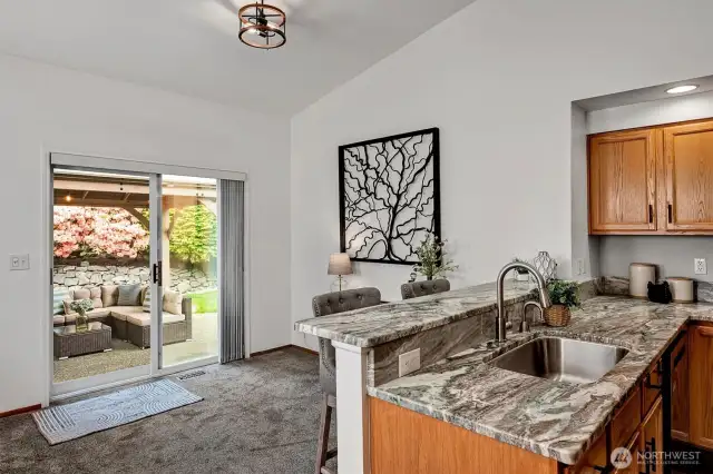 Sliders off dining area lead to incredible, fully-fenced backyard