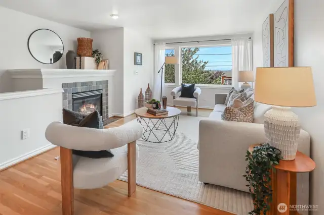 Living room has westerly views, a gas fireplace and hardwood floors.