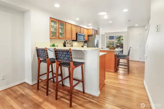 The kitchen features a high counter for chairs as well as an island with seating options.