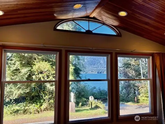 Den room with vaulted ceiling, laminate plank flooring and pretty views of Lake Quinault and surrounding mountains.