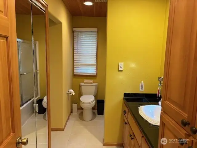 Continental bath with access to primary bedroom and main hall. Combination tub/shower and laundry closet.