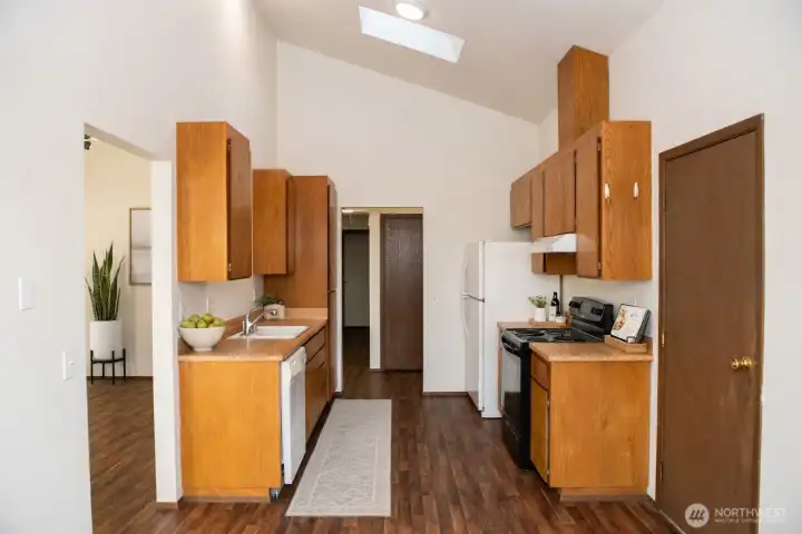 Virtually Staged kitchen with professionally freshly varnished cabinets with ample storage and lots of potential.