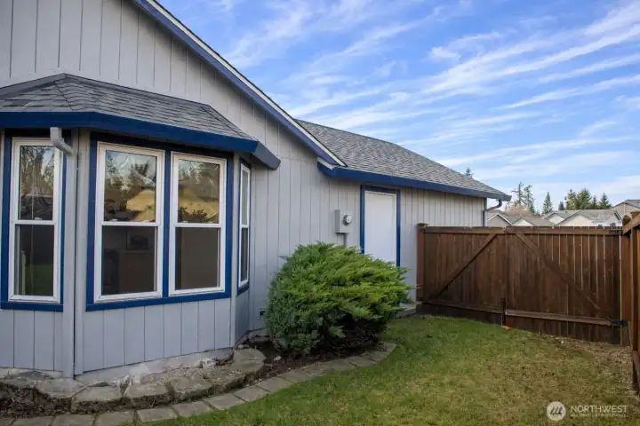 Side yard with gate, next to dining room bay window.