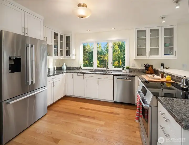 All appliances replaced in 2025. Stone countertops, lots of cabinetry and a lovely view from all sides. Separate pantry closet is adjacent to this space.