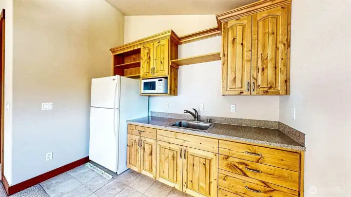Mini kitchen in the bonus room with an apartment size frig/freezer, microwave and sink.