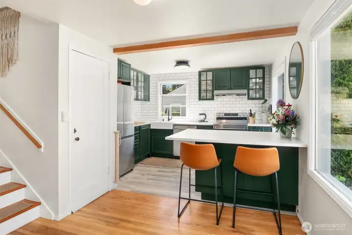 Beautifully updated kitchen with lots of cabinet space and work surfaces, and an eating bar that opens to the living room