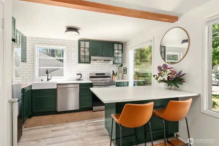 Beautifully updated kitchen with lots of cabinet space and work surfaces, and an eating bar that opens to the living room