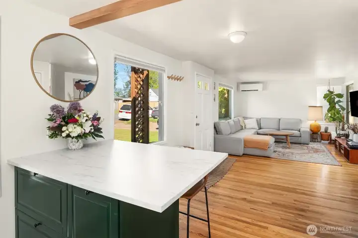 Eating bar that opens to the sun-filled living room with gorgeous hardwood oak floors and great light from the tall, south-facing windows