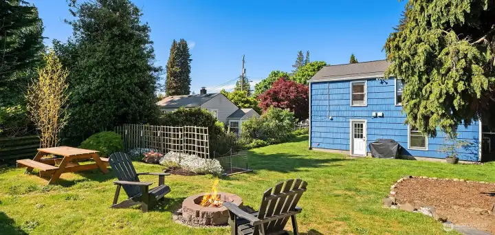 Huge, fully fenced, peaceful backyard with fire pit, picnic table and garden beds