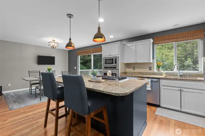 Kitchen designed for entertaining with granite countertops, oversized island, and a gas range.