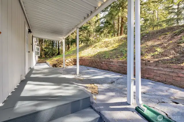 Covered side yard patio area with walkway from driveway to back yard area.