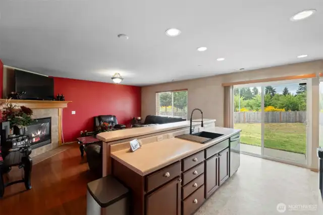 The kitchen overlooks the backyard and flows into the inviting family room, featuring a stylish accent wall and cozy fireplace.