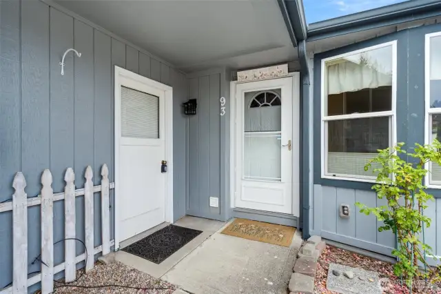 Inviting covered front porch with easy-care landscaping and private entry door.