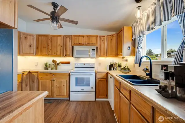 Spacious kitchen with abundant counter space, ceiling fan, and all appliances included. (Virtually staged)