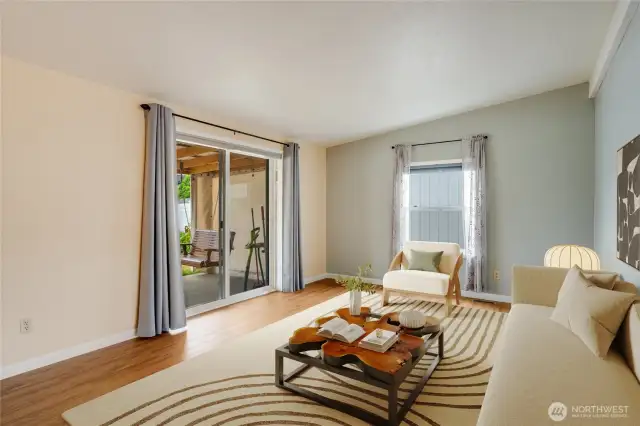 Living room opens to the backyard covered patio for seamless indoor-outdoor living. (Virtually staged)