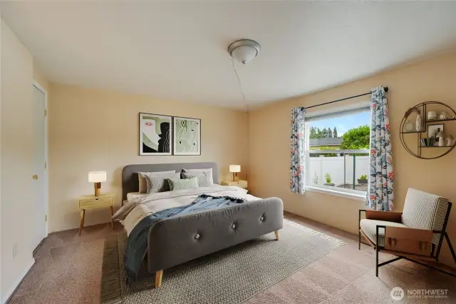 Comfortable primary bedroom with large window and warm natural light. (Virtually staged)