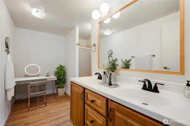 Primary bath features a modern vanity, roomy counter, and a separate make-up area. (Virtually staged)