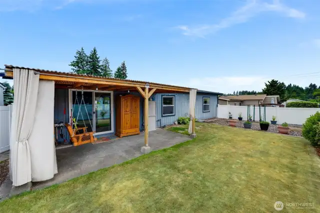 Fully fenced w/easy maintenance vinyl fencing--private backyard with a covered patio and lush lawn, ready for quiet mornings or casual gatherings.