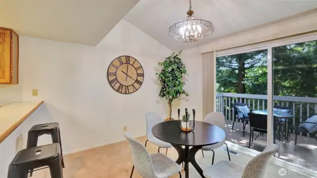 A grand sliding glass door and vaulted ceilings create a sophisticated, light-filled dining space with timeless design