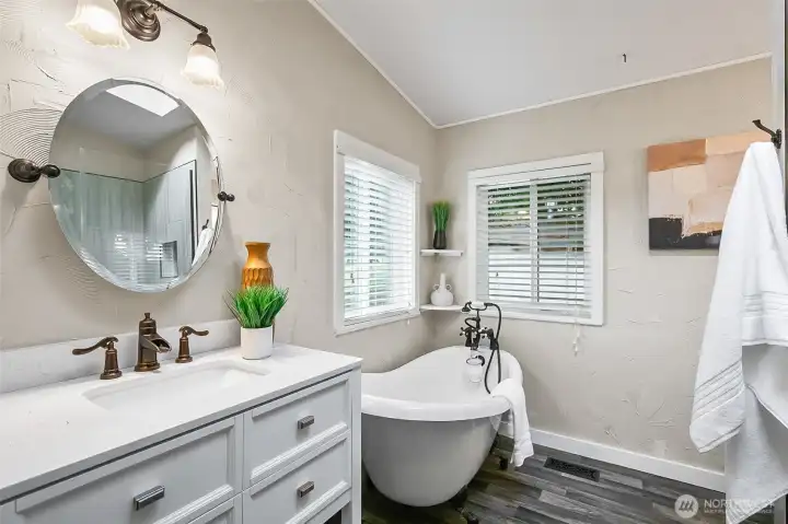 Remodeled primary bathroom with tub and shower.