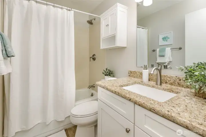 Hallway bathroom is beautifully appointed and spacious.