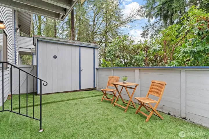 Private, fenced patio offering a peaceful outdoor retreat—perfect for morning coffee or evening relaxation. Enjoy pet friendly, low-maintenance turf, space for seating, and convenient exterior storage, all with direct access from the living area for seamless indoor-outdoor living.