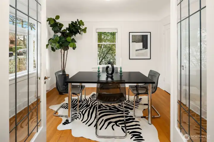 Leaded-glass French doors with crystal doorknobs lead to the first bedroom—perfect as an office, dining room, or flexible living space.