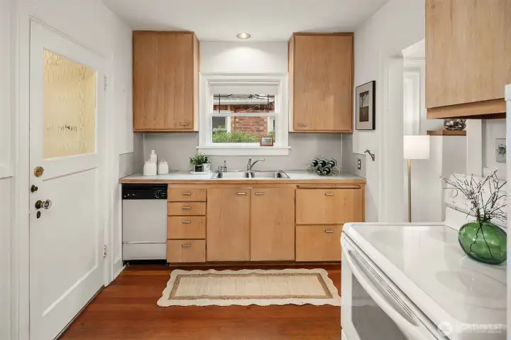 Charming kitchen detailing clean finishes and flat-panel wood cabinetry.