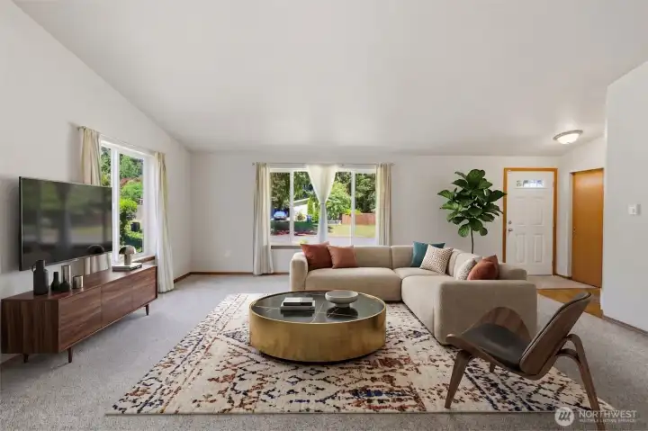 Virtually staged. Bright and airy living room with vaulted ceilings, dual-aspect windows, and direct sightlines to the entry and dining area.