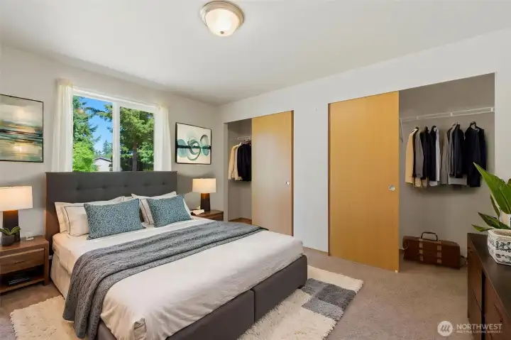 Virtually staged. Generously sized second bedroom featuring double sliding closets and a bright window overlooking the tree-lined yard.