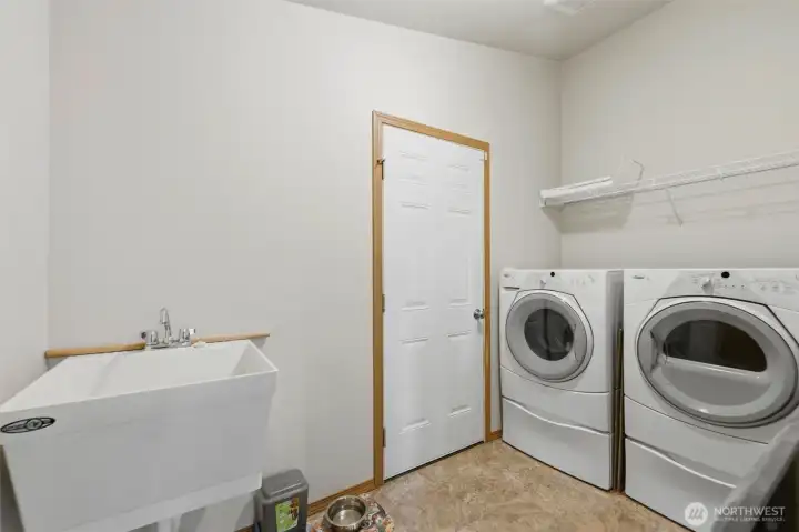 Dedicated full-size laundry room with included washer & dryer, utility sink, and built-in shelving for extra storage.