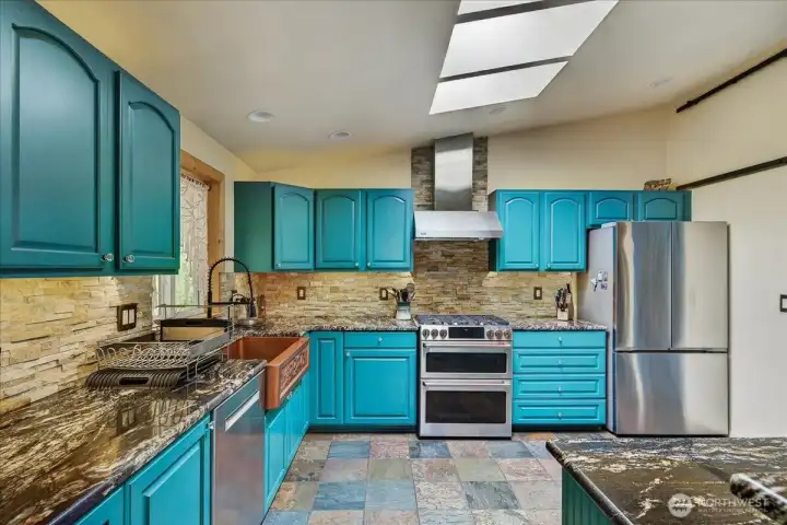 Functional kitchen with lots of cupboard space, window overlooking the backyard, copper sink, skylights, walk in pantry, cabinets are painted with glass pulls - a really beautiful space that offer enough space for many cooks in the kitchen at one time.
