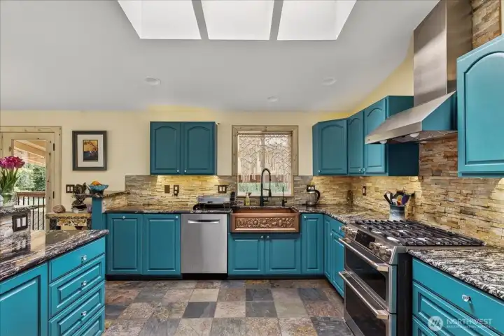 Beautiful kitchen that is spacious enough to entertain on the holidays or any occasion. You will find a gas cooktop, copper sink, ss appliances, beautiful painted cabinets with glass pulls. Lots of natural light from the skylights. Kitchen sink that overlooks the beautiful backyard. The kitchen is open to the dining and living room - a very beautiful space.
