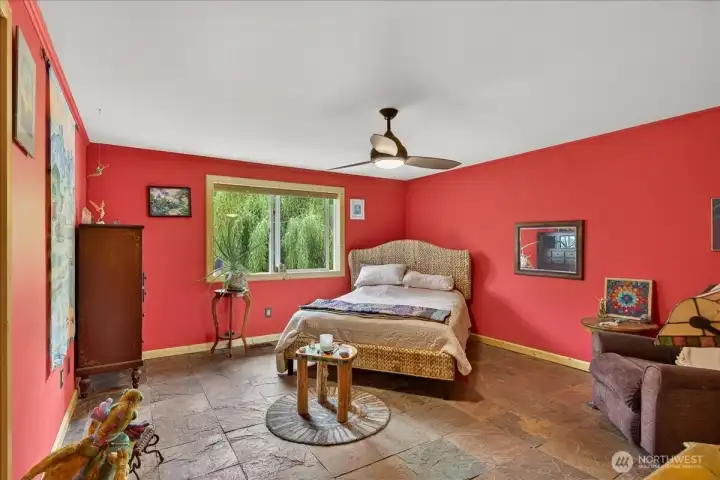 Spacious primary bedroom suite, window overlooking the backyard. This room offers heated floors in the bedrooms, heated floors in the large walk in closet & the ensuite bathroom. This space feels like you are at a beautiful resort.