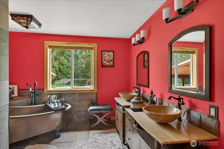 This is the primary bathroom suite - you will find heated floors, travertine vanity with copper clawfoot tub, large stone shower - this space is tranquil and a beautiful space to enjoy a soak in the tub after a long day.