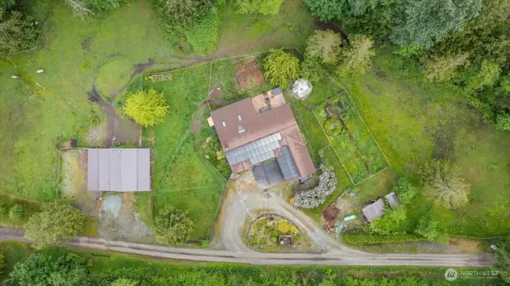 Aerial footprint that showcases the house (solar panels), fenced designated garden space, additional outbuildings and shop/barn - Thoughtfully laid out to get the best use of the land. Currently being used as equestrian property, however, would make a great hobby farm or excellent option if you need more space!