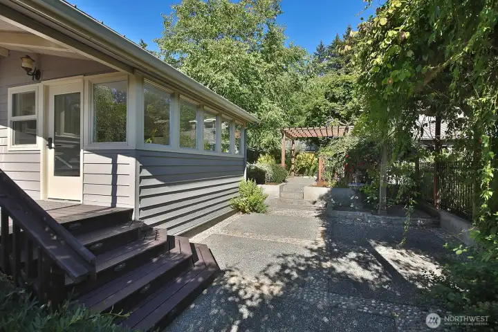 Deck leads to courtyard with quaint garden setting.