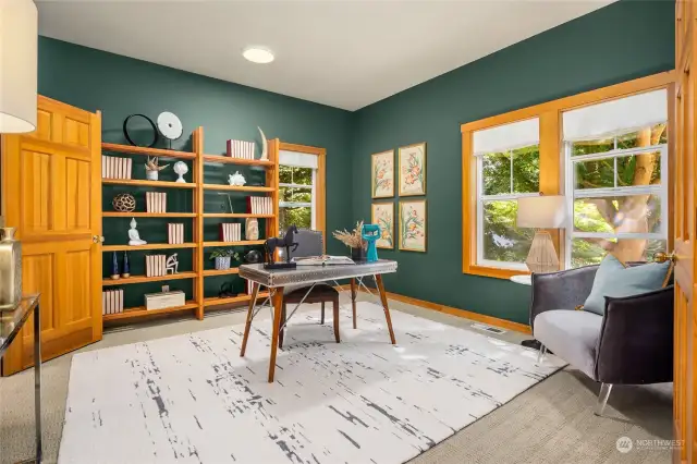 A lovely home office has built in book cases and doors on each side for easy access and privacy.