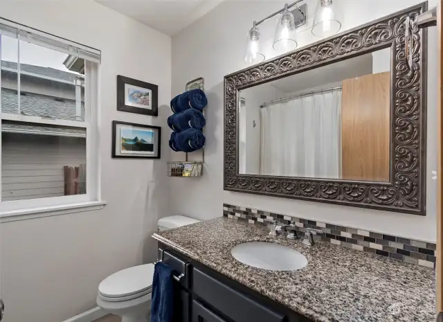 Hall bathroom with tile floors and granite countertop.