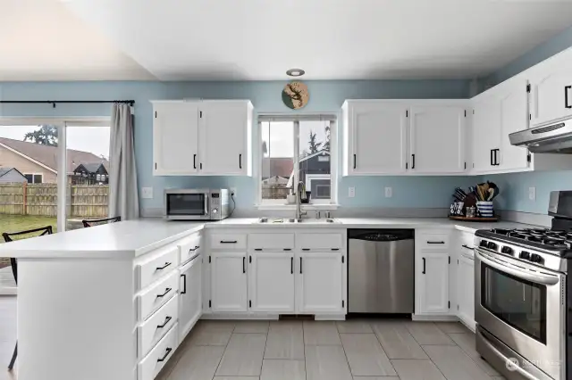 Stainless steel appliances, gas stove and tile floors.