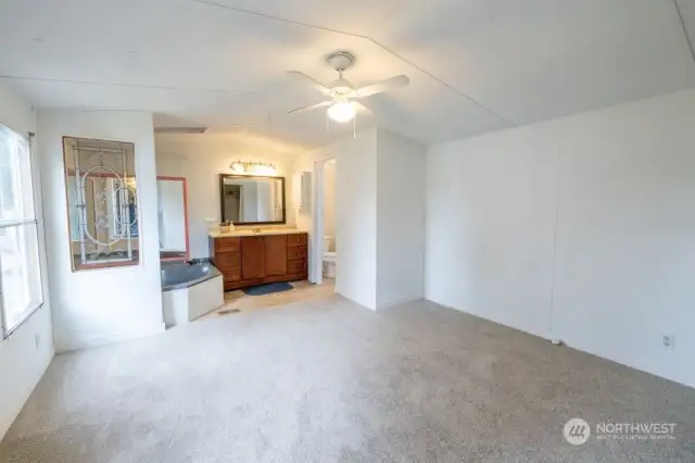 Spacious primary bedroom on one wing of the house with full bath.