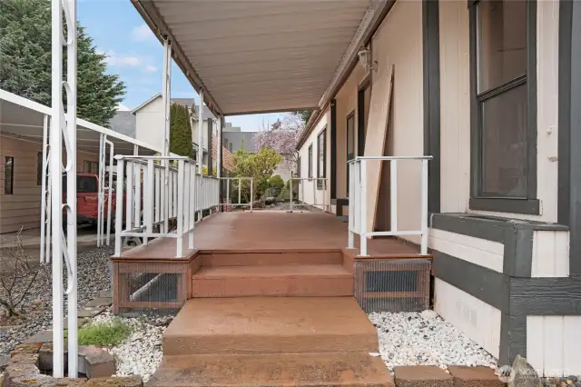 This home features a large covered deck at the front entry, with an uncovered deck beyond...