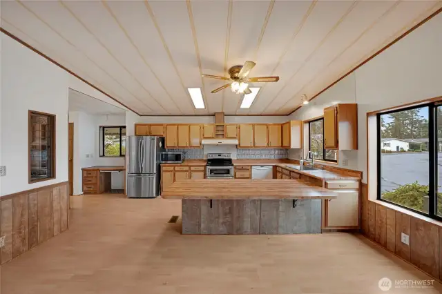 Large Kitchen with plenty of cabinets and counter space, stainless-steel appliances, and a workstation desk to the left of the refrigerator.