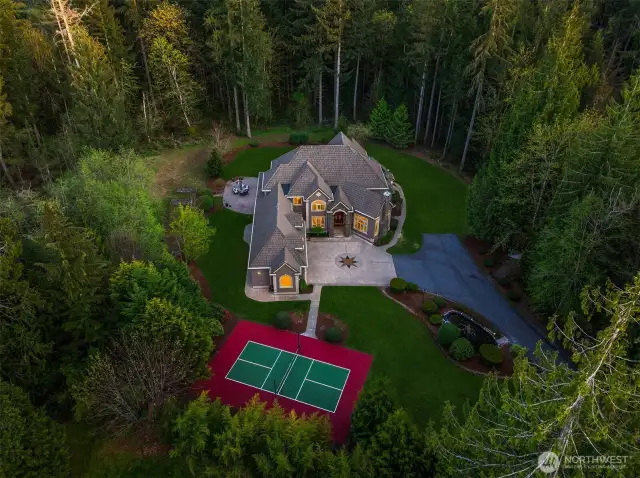 Property extends beyond the tall trees on all sides and abuts a protected wetland beyond the fir trees to the right