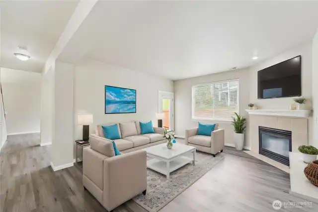 Family room with cozy gas fireplace and patio access. Virtually staged.
