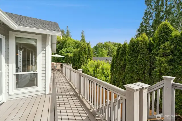 Sun-drenched and inviting deck just outside the Primary bedroom with a view towards the dining area. Lush landscaping offers a bit of privacy too!